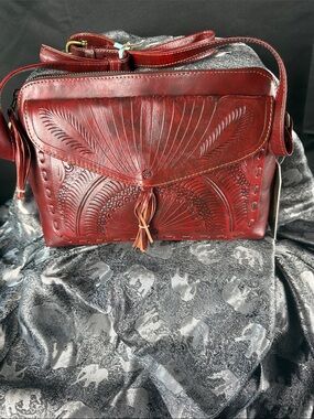 Hand-Tooled Burgundy Leather Crossbody Bag with Tassel Accent